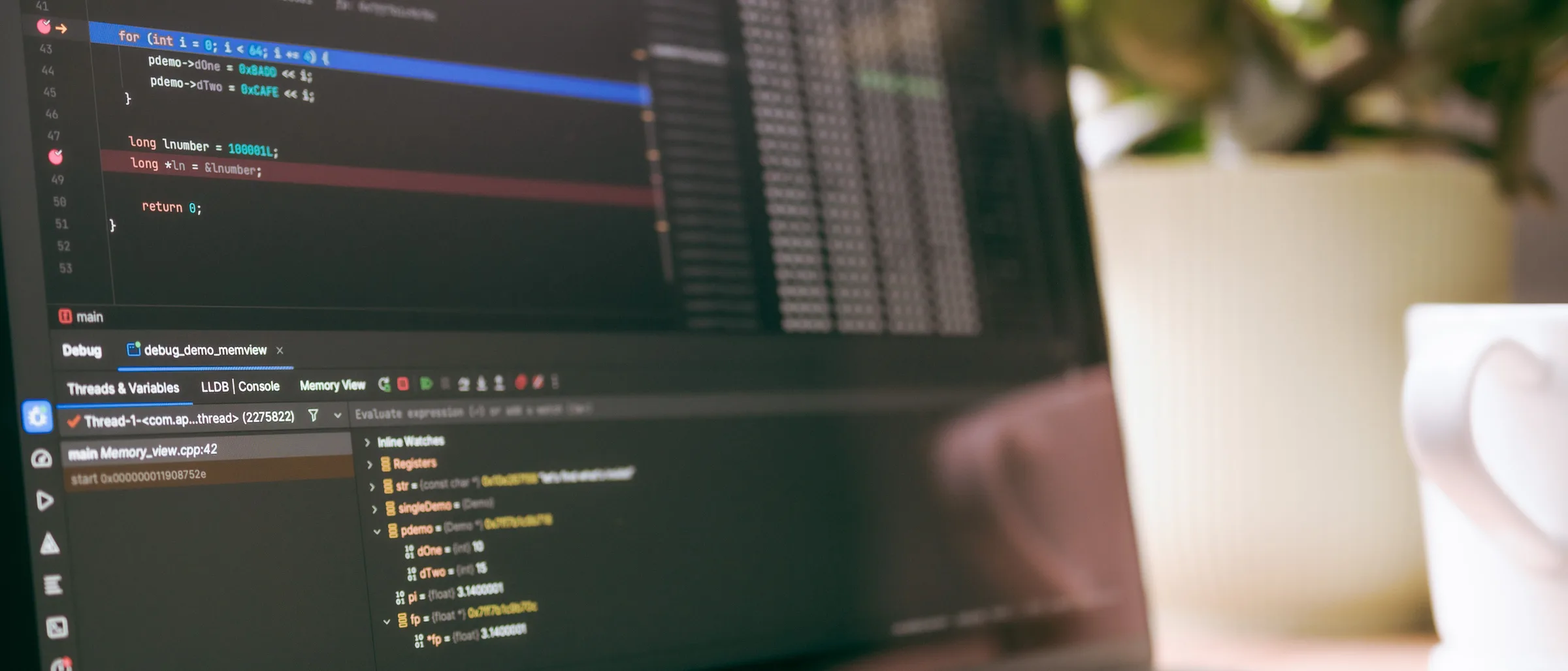 A designer's workspace with a laptop screen showing interface layouts.